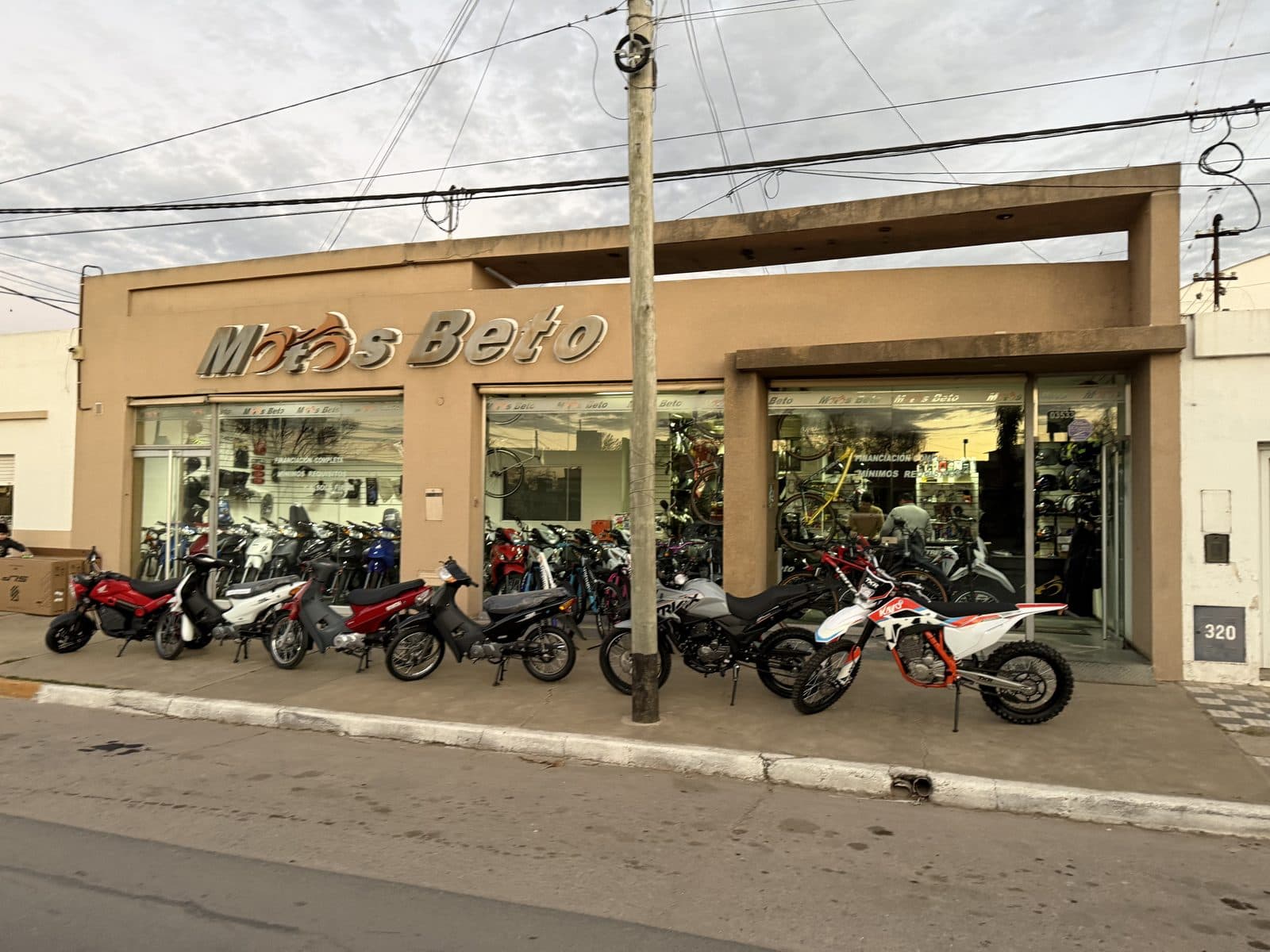 Frente del local sobre B. Mitre, con el cartel "Motos Beto" y una fila de motos estacionadas en la vereda.